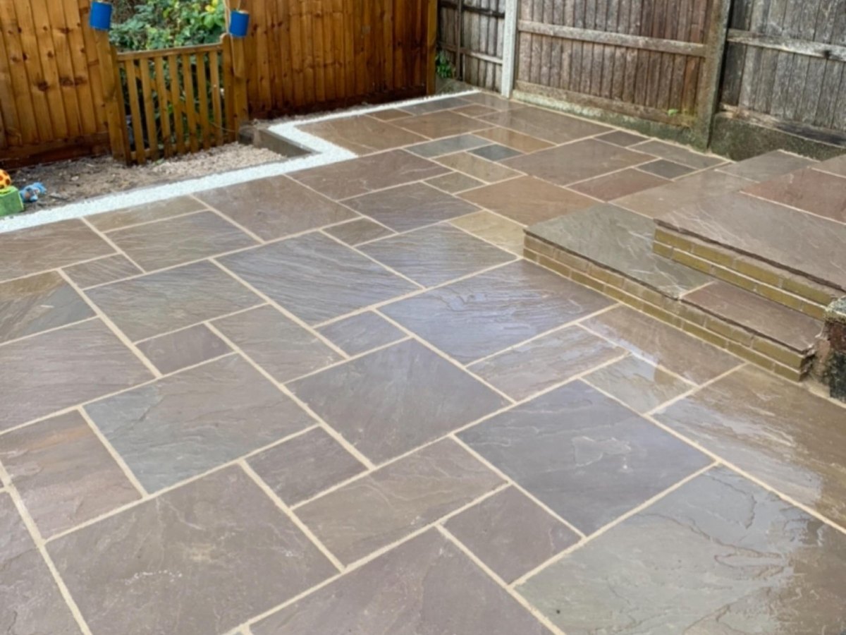 Stone patio seating area with timber decking and outdoor chairs